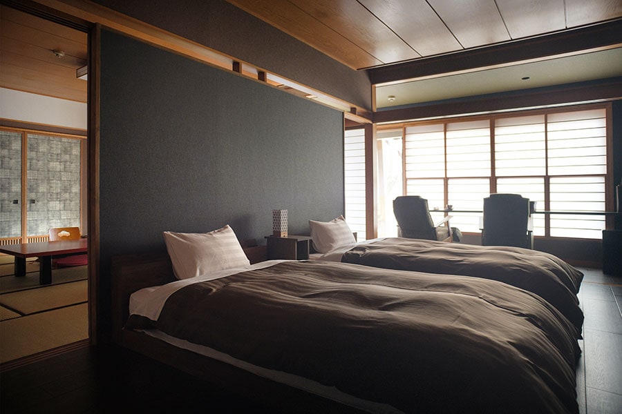 露天風呂付き特別室『松島』の洋間の和モダンなツインベッド。広めの和洋2間の客室で、ゆったり落ち着いて過ごせます。