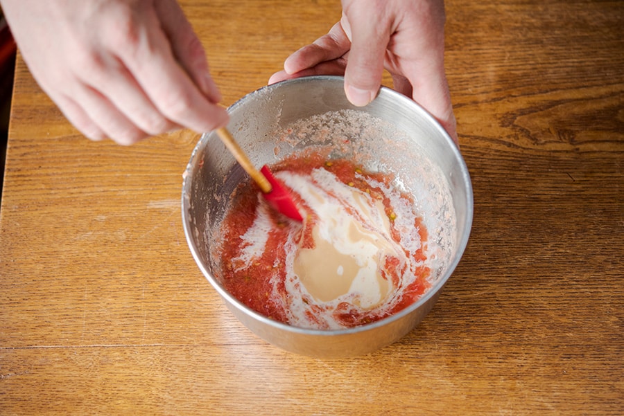 すりおろしたトマトをボウルに入れ、ごまだれや豆乳と混ぜ合わせスープジャーに入れる。
