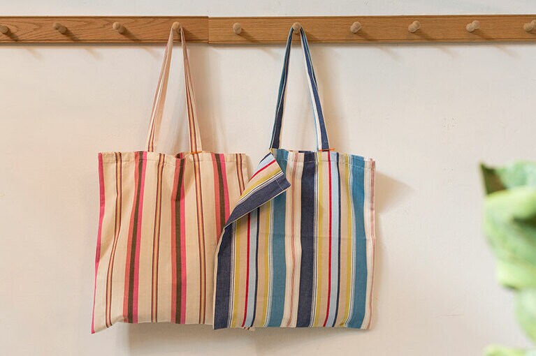 イギリスの丈夫なストライプ生地を使ったショッピングバッグ 各4,200円。