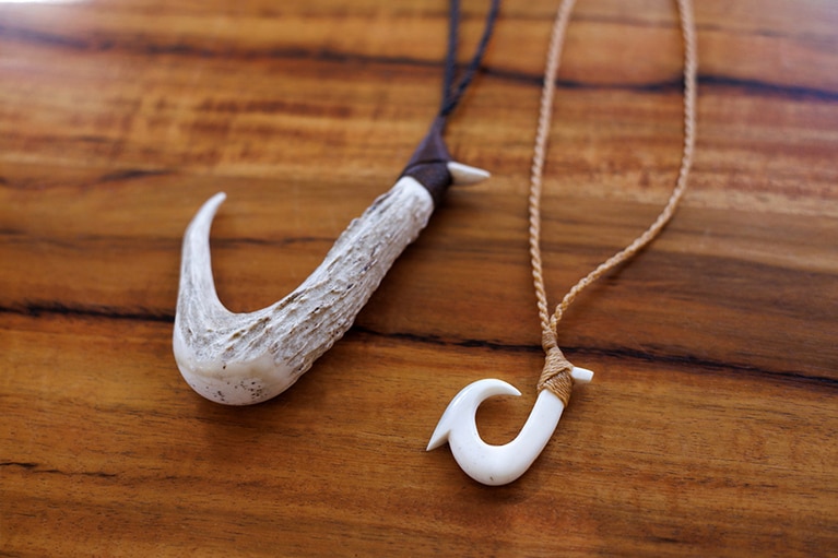 ハワイの伝統漁具である鹿の角の釣り針をペンダントに。左から180ドル、90ドル。