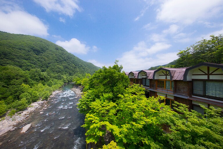 星野リゾート 奥入瀬渓流ホテル［青森／奥入瀬渓流温泉］渓流から望むホテルの外観。