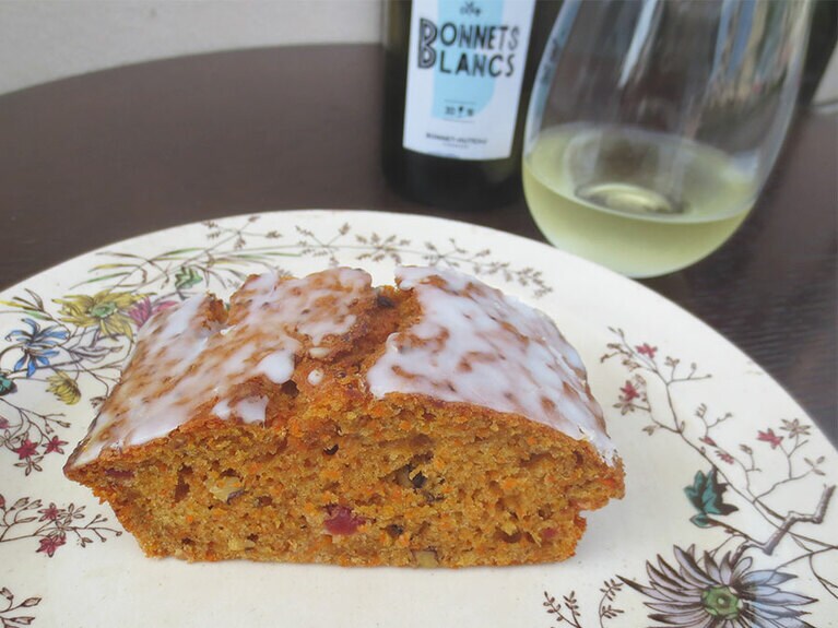 「キャロットケーキ」350円と「白ワイン・グラス」700円～。甘さ控え目でスパイスが香り、クランベリーとクルミの風味が、オススメの白ワインにマッチ。