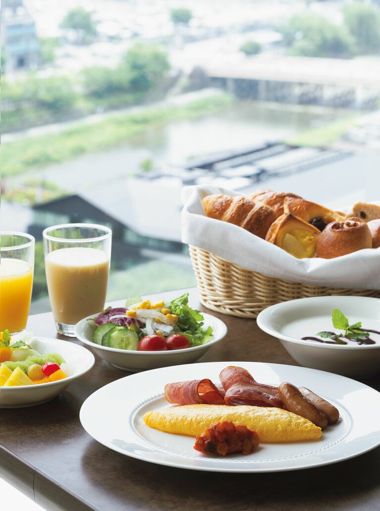 レストランの大きな窓からは京都を一望できる。東山三十六峰の美しい景色も楽しめる。シェフおすすめのしょうがを効かせたミックスジュースは、爽やかな飲み口で料理とも合う。