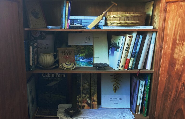 部屋のチェストを開けると、たらい舟職人さんが作った“ミニたらい舟”がお目見え。「モリスセミダブル」は、佐渡や旅にまつわる本とコーヒーを楽しめます。