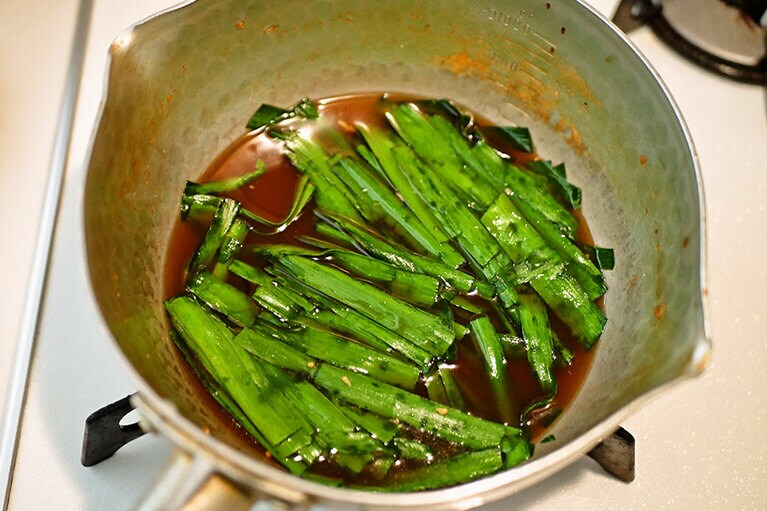 最後にニラを1分ほど煮て、盛りつけます。スペース的に余裕がなかったので、私は豆腐とブリをうつわに移してから、ニラだけを入れてサッと火を通しました。ニラはすぐ火が通ります。