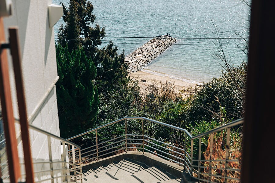 ホステルへのアプローチは少々急階段だけに、眼下に広がる眺望がすばらしい。朝、砂浜の散歩もおすすめ。
