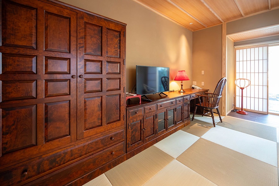 客室「こまくさ」の畳のベッドルームに置かれた、カバの木で設えた松本民芸調の家具。