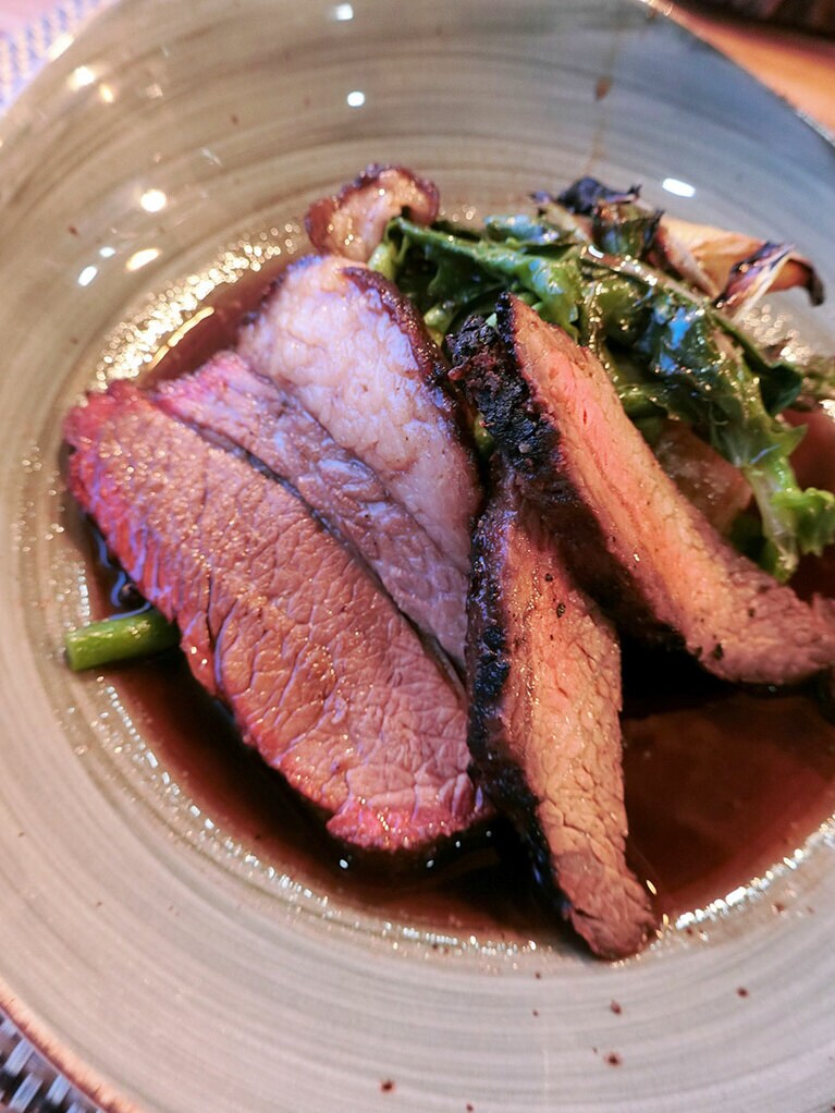 島で育った牛のグリルにソースをかけて。