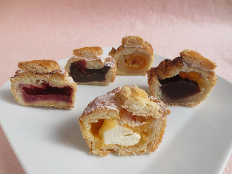 ミニパイの断面。手前より時計回りで「レモンクリームチーズ」「ストロベリーホワイトチョコ」「ラズベリーチョコレート」「金柑と白餡」「あんもち」。