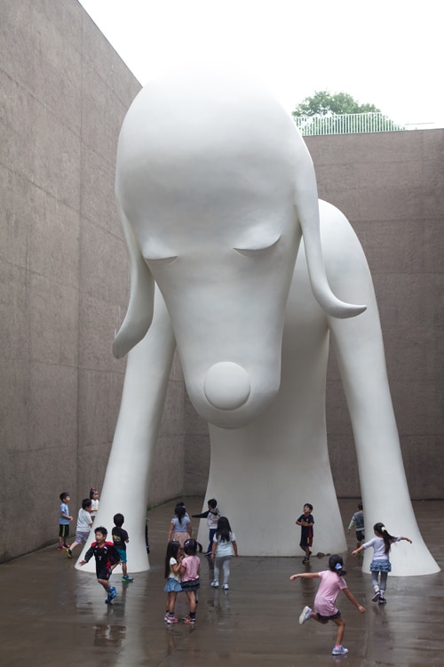 奈良美智《あおもり犬》2005年 ©Yoshitomo Nara／高さ8.5mもの巨大なオブジェは、隣接する「三内丸山遺跡」に発想を得て、下半身が地中に埋まっている“発掘中”の姿に。