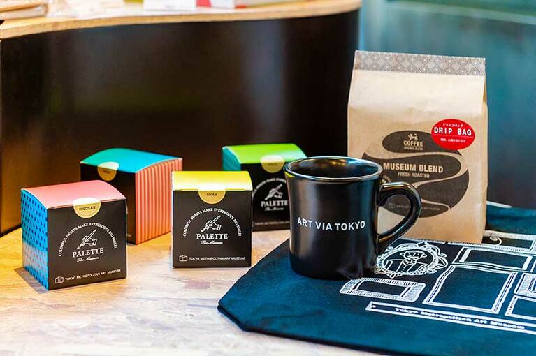 左上から、オリジナルスイーツ「パレット」鮮やかな色を組み合わせてギフトに。4種 各540円。マグカップ 1,870円。ミュージアムブレンド ドリップバッグ 7個1,080円。額縁デザインの都美バッグは缶バッジなどをアレンジ次第で楽しさが広がるデザイン。1,300円。