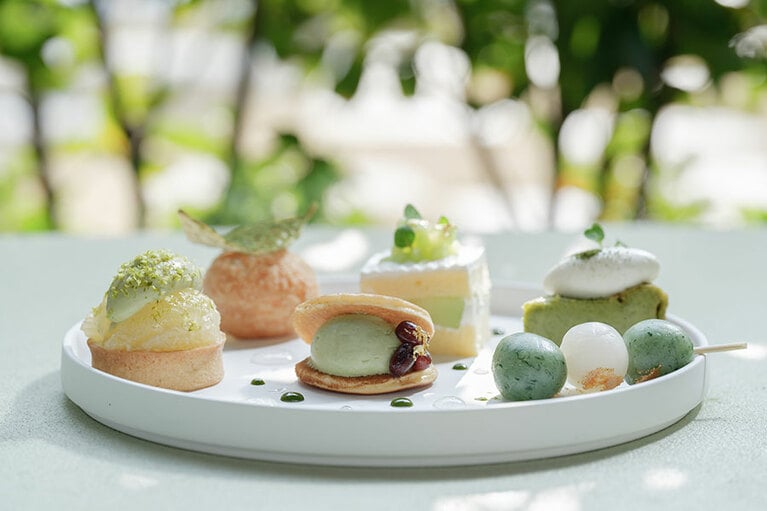 「小山芳月堂」で長年親しまれている、ふっくらとしたどら焼きには、香り高い抹茶のホイップクリームを合わせ、能登大納言をあしらっている。