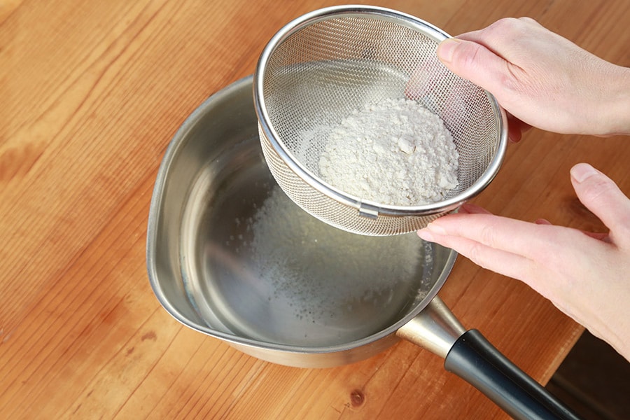 片手鍋に太白ごま油を入れて地粉をザルで振るい入れる。