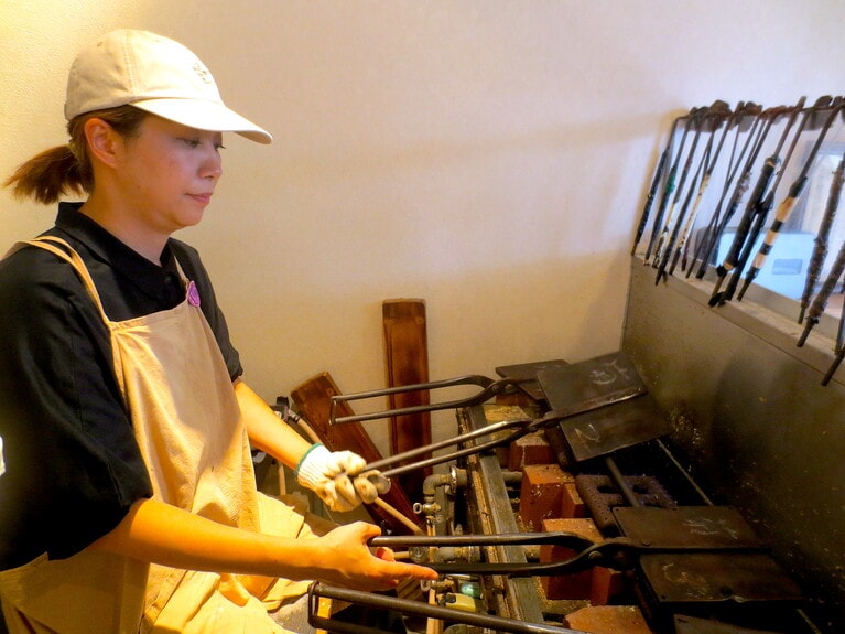 重い鉄板を回転させながら、おせんべいを焼き上げる。