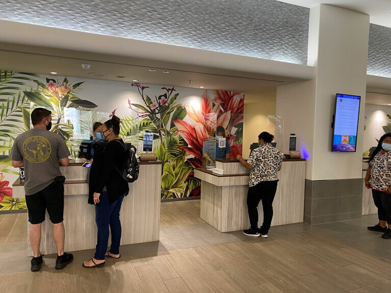 マスク着用でチェックイン。カウンター右には自動検温機を設置。