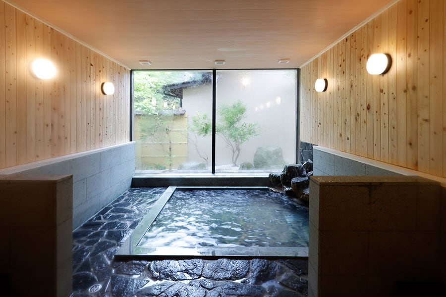 浴槽の壁には檜、床や浴槽にはしっとりした肌触りの十和田石を使用した大浴場。