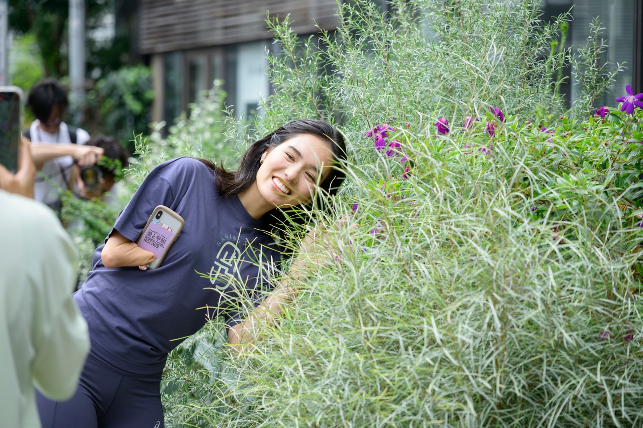 参加者たちと話しながら歩き、花を見つけて撮影する姿も。