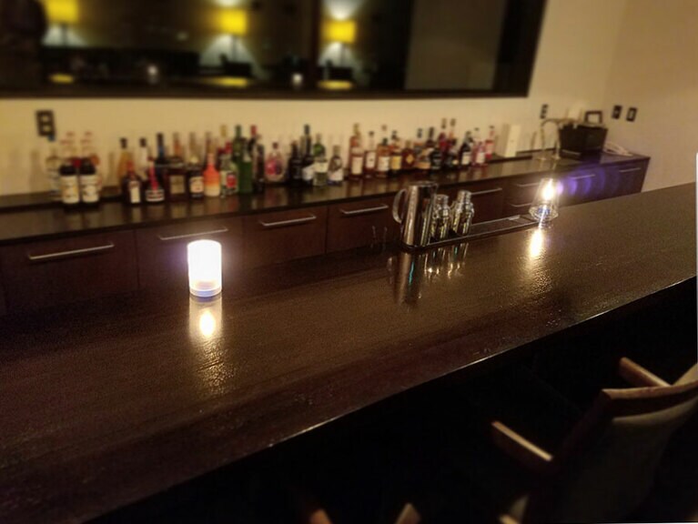 「RIDGE Bar」は、アンティーク調の木目カウンターに10席ほど。後ろに2人用のテーブル席が4セットある。