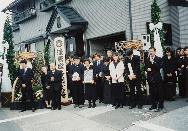 妹さんの告別式。白い半袖服姿の後藤さん。（後藤さん提供）