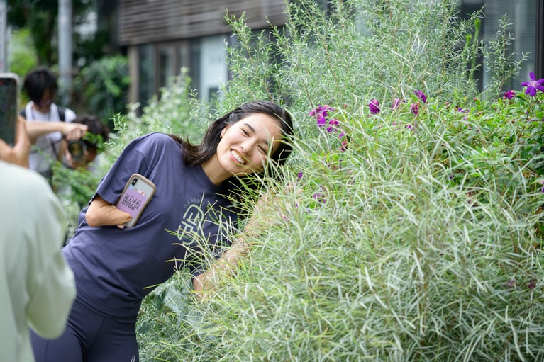 参加者たちと話しながら歩き、花を見つけて撮影する姿も。