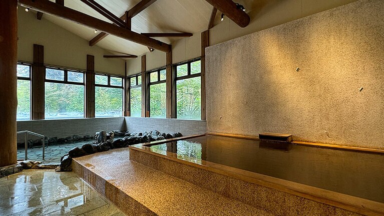 手前の檜風呂が「あつ湯」で、奥の岩風呂が「ぬる湯」。内湯とはいえ開放感がある。