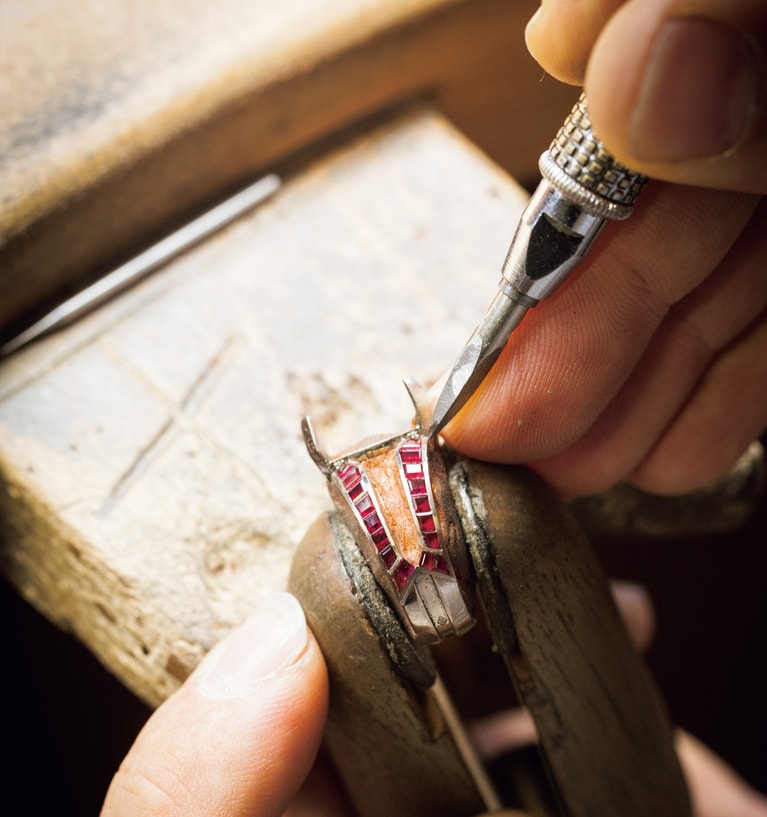 チャネルセッティングという技法でルビーを留める工程は、集中力が必要とされる。プレシャスメタルの細工と宝石のセッティングは専門職が分かれていて、何人もの職人たちがひとつのジュエリーに関わって仕上げる。