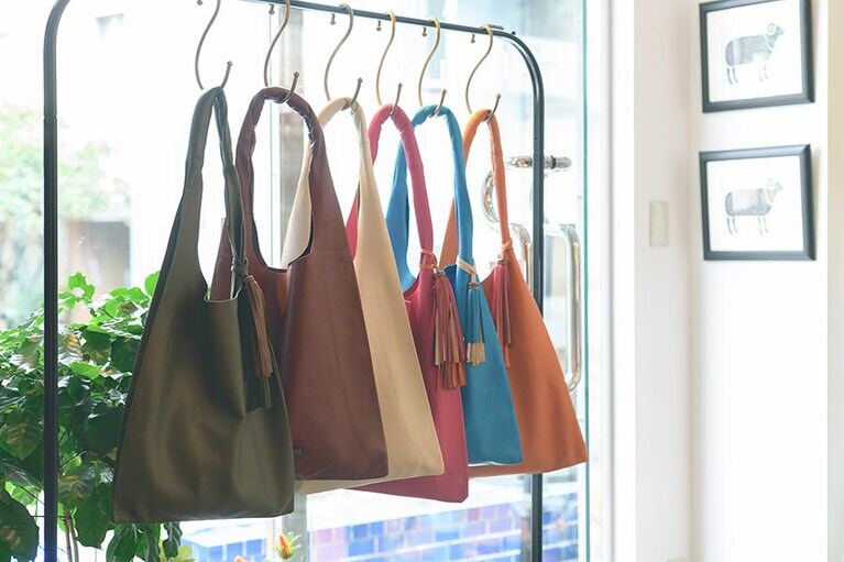 薄さ、軽さが際立つ「Airy」 24,000円。わずか100g、卵2つ分の軽さ。A4サイズの書類やPCも入る。ピンクやブルーの鮮やかな色が、暗くなりがちな冬のファッションの差し色に。バッグチャームは別売り。