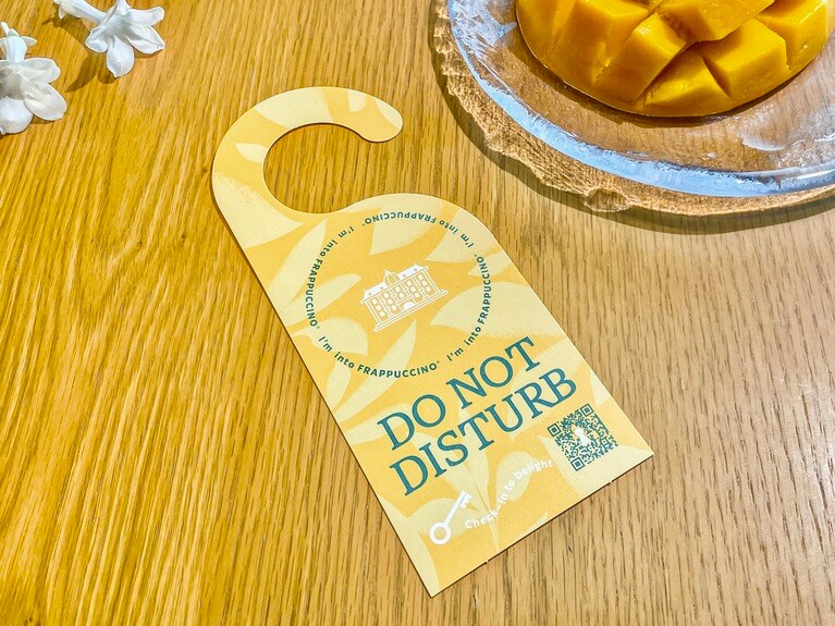 「オリエンタル マンゴー ＆ ティー フラペチーノ®」限定デザインのコースター。ハンドオフカウンター（商品を受け取る場所）で自由に持ち帰ることができます。