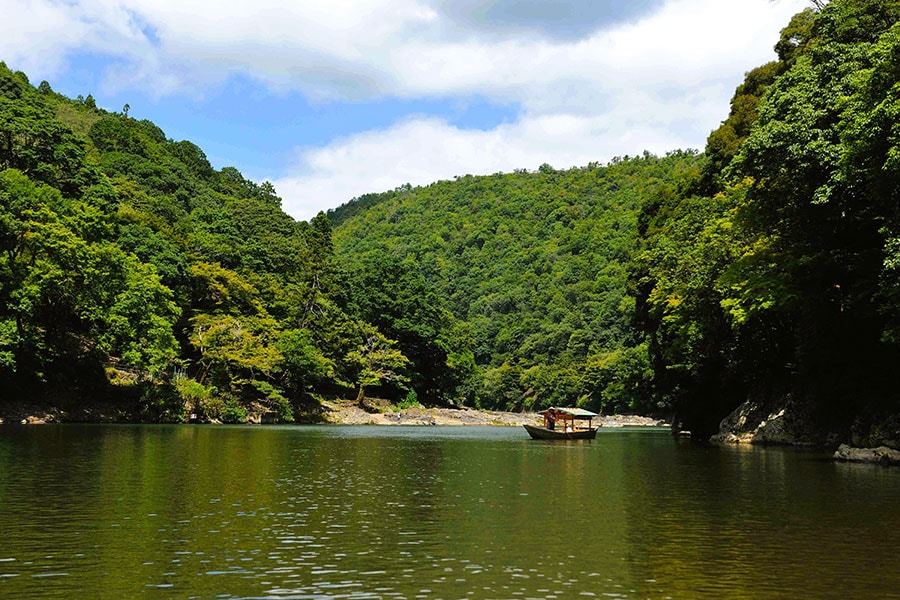 渡月橋の上流、大堰川に浮かぶ星のや京都専用の屋形舟「翡翠」。嵐山の花鳥風月を愛し、いまに残る歌を詠んだ平安貴族のような、優雅な舟あそびが叶う。