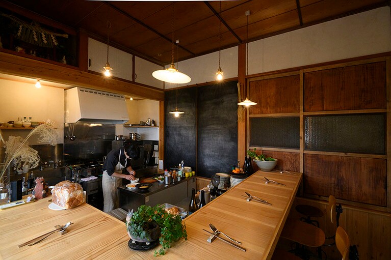 オープンキッチンを囲んだL字型のカウンター7席。襖の漆や店内の漆喰、外壁は自分で仕上げたそう。