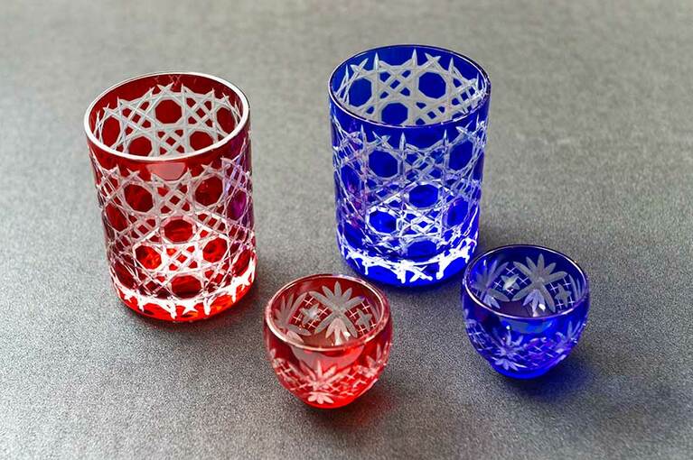 見事な細工の江戸切子は、昔も今もとびきりの贈答品として定番。籠目模様のグラス(各27,000円)は特別な贈り物に。矢来笹紋の小丸盃は1個6,000円とお土産にも手頃。