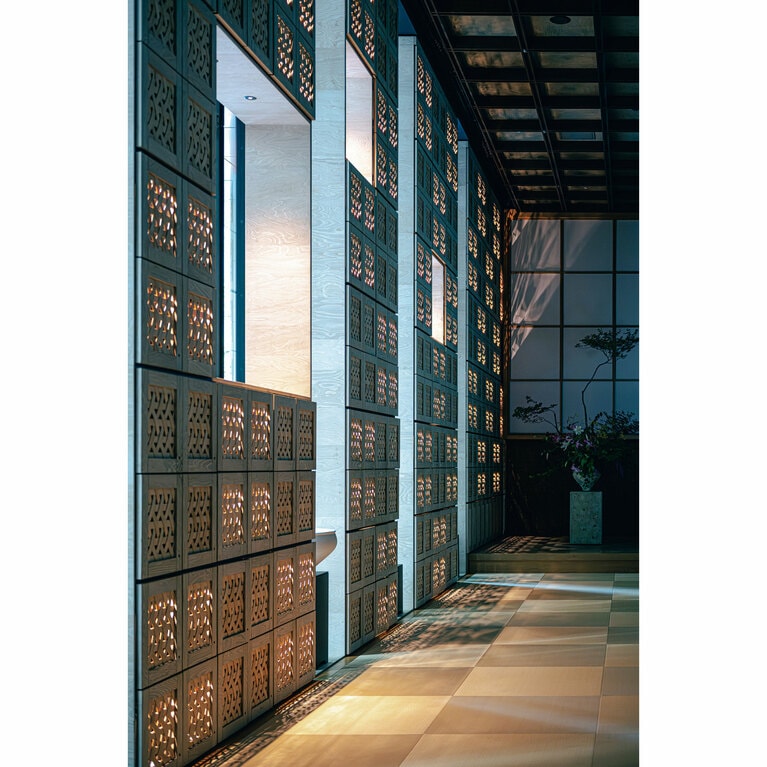 正面玄関の廊下。隣り合う畳の「目」の方向を変えて敷くことで市松模様を表している。正方形の靴箱を積み重ねた壁にも調和したデザイン。