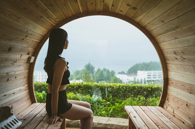窓の向こうに西海岸の風景を眺める、絶景のバレルサウナ。