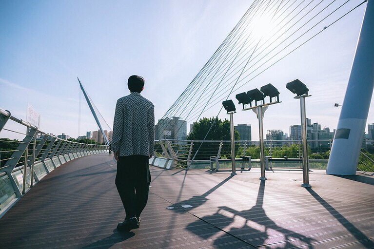 歩道橋では犬の散歩やランニングをする人、ビジネスマンなどが行きかう。