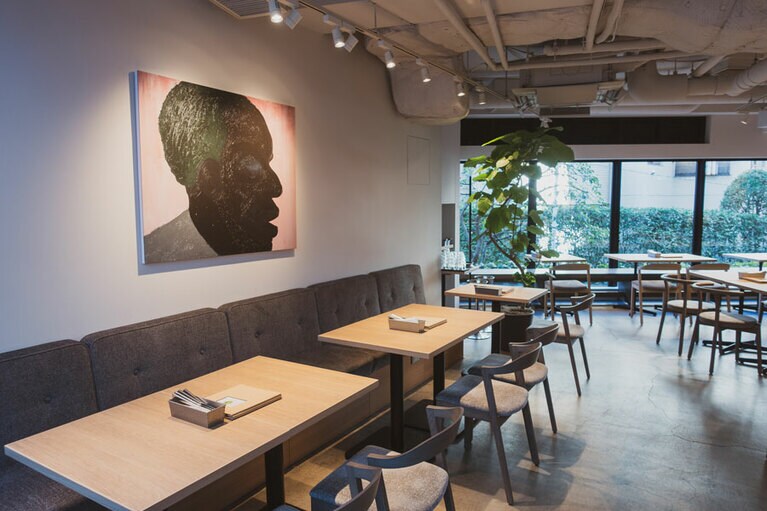 壁に飾られたスズキ タケシの作品が印象的な店内。