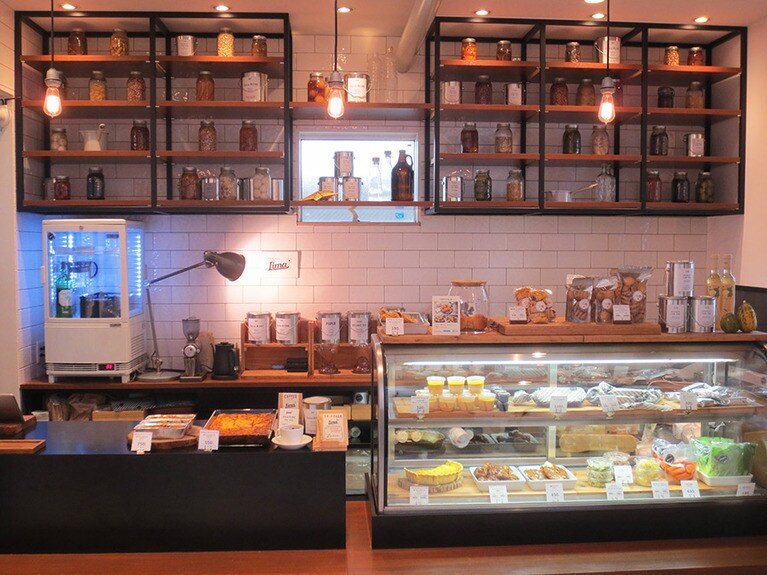 店内。ショウケースとその回りに、お総菜とお菓子が並んで。