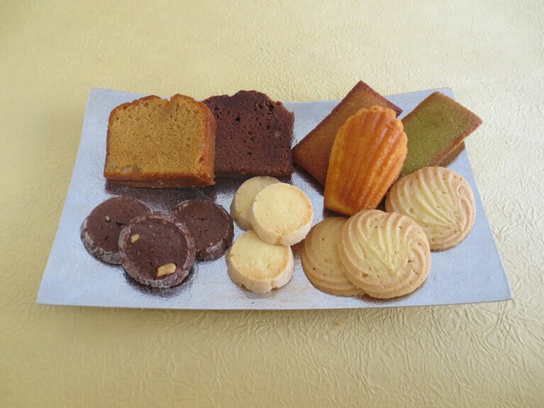 左上から時計回りで、「キャラメルのパウンドケーキ」200円、「ショコラのパウンドケーキ」200円、「フィナンシェ」200円、「フィナンシェ・ピスターシュ」200円、「マドレーヌ」200円、「フィナンシェ」200円、「サブレヴァニーユ」1袋200円、「サブレココ」１袋200円、「サブレショコラ」1袋200円。
