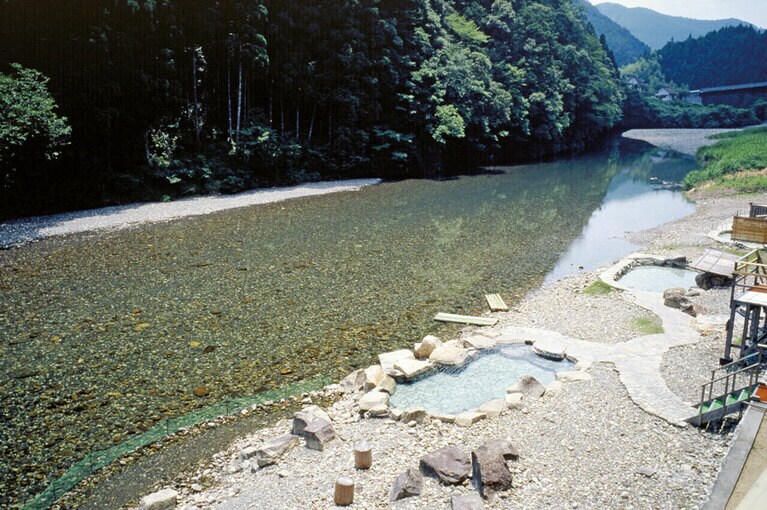 【山水館 川湯みどりや】奥熊野の山間にあるこの宿は、熊野川の支流、大塔川の川原から温泉が湧き出るという珍しい露天風呂がある。混浴だが女性は温泉浴衣を着て入るので気がねなく楽しめる。檜や杉などの常緑樹の山景色は冬でも緑豊かでほっとさせられる。部屋はスタンダードと露天風呂付きの2タイプ。熊野古道への無料送迎付きでひとりでも気軽に巡れるのが嬉しい。