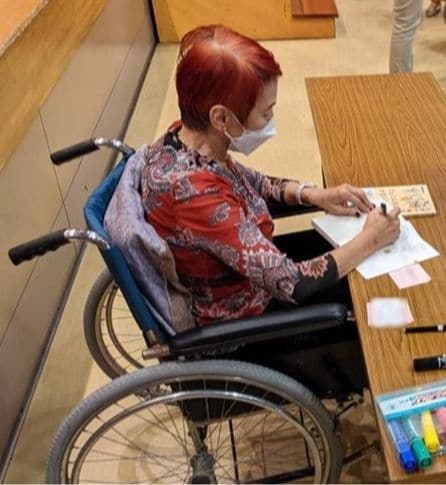 骨折当日の上野さん。車椅子姿でサイン会もこなした（長門市しごとセンターHPより）