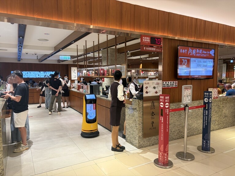 入り口前のモニターには、現在の待ち時間や呼び出し番号が表示されます。入店後はQRコードを読み取って注文。日本語にも対応しています。