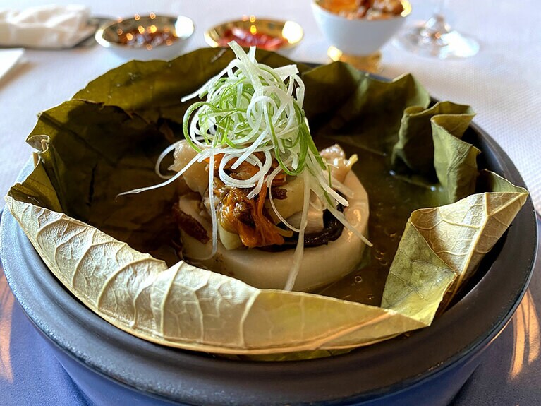 レンコンを土台にして、地鶏、きくらげ、金針菜などが蓮の葉に包まれ蒸されている。