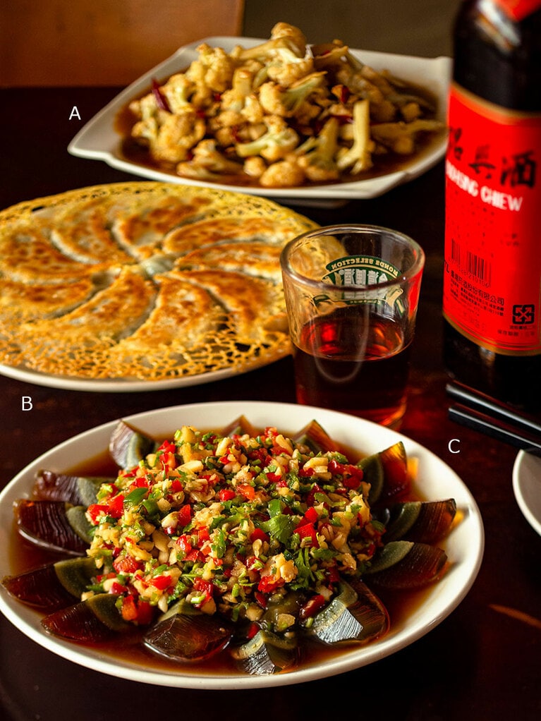 A：カリフラワーの酸辣炒め「醤爆白花菜(ジャンバオバイファツァイ)」180元。「酸味と辛みがきいて、箸が止まらない一品」 B：スパイシーニラ餃子「黄金韮菜鍋貼(ファンジンジウツァイグゥオティエ)」200元。餃子の餡は肉ナシで、細かく刻んだニラ、干し豆腐、春雨など。香ばしさに満足感もひとしお。 C：ピータンの彩り薬味がけ「涼拌皮蛋(リャンバンピータン)」200元。パプリカやねぎ、ショウガなど薬味もたっぷり。辛みも強いので“小辣”でオーダーを。