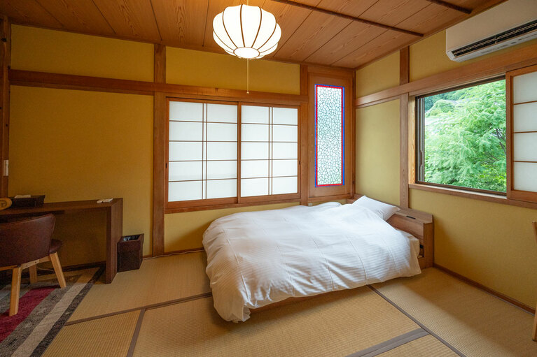 和室にベッドが置かれたシングルルーム「欅の間」。