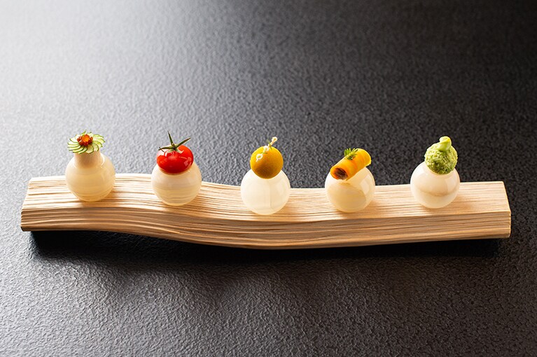 シグネチャー料理は「五つの意思」。五味（酸、塩、苦、辛、甘）をそれぞれ小さな一つの料理で再現。料理に合わせて、土台にする石の温度も変えている。