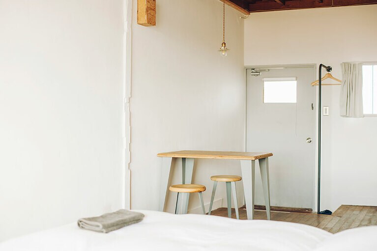 シンク、冷蔵庫、電気ケトル、テーブル＆チェア。必要最小限なものが揃う室内。