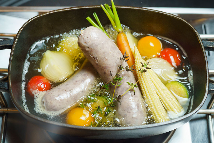 ダッチオーブンで猪のソーセージや季節野菜を煮込み、スープと具材に分けていただく。