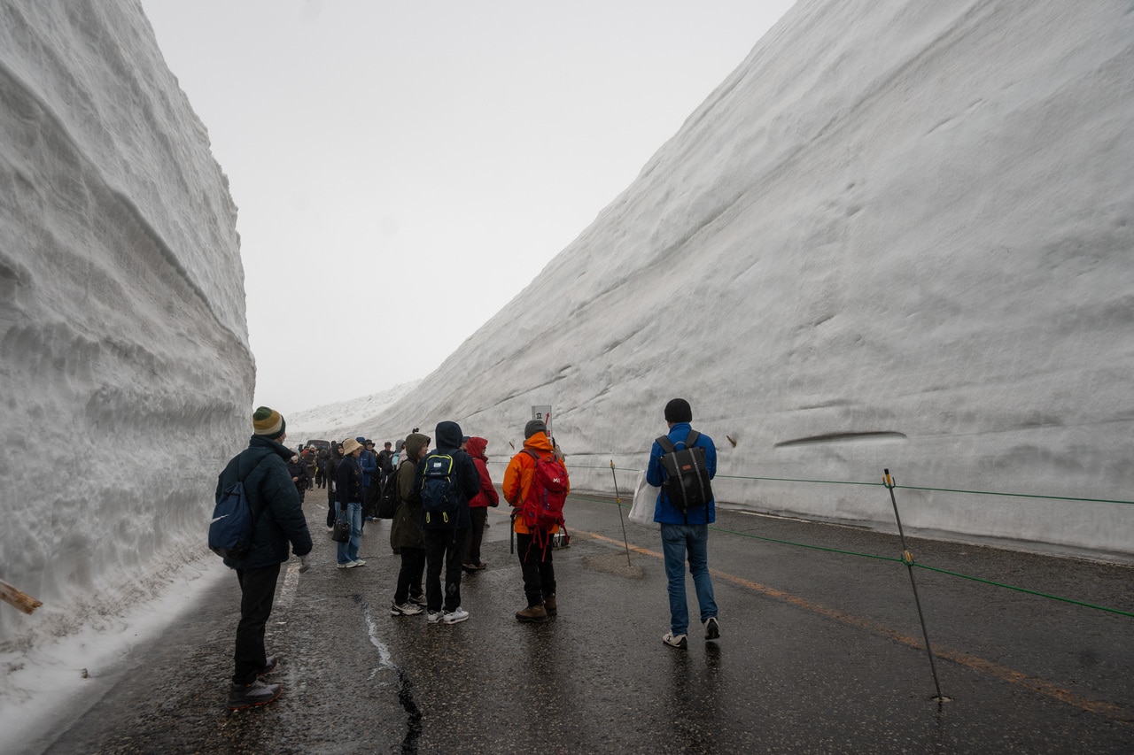 道の両側に、見上げるほど高い雪の壁が延々と続きます。人の背丈と比べると、そのスケールの大きさに驚かされます。