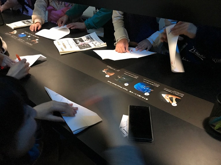 紙飛行機を造って飛ばすコーナー。子供たちが熱心に紙飛行機を折っていた。