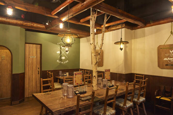 アルペンジローカリーのルーツは尾瀬のスキー場の宿泊ロッジ。その世界観を継承し、店内は山小屋をイメージした木のぬくもりを感じるデザイン。カリーはスキレットで、炊き立てごはんは飯盒のままで提供される。