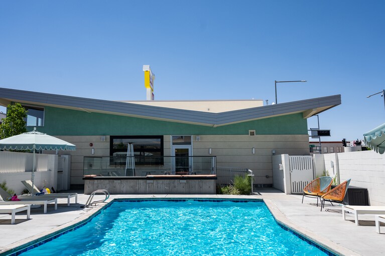 屋外プール。ミッドセンチュリーモダンを象徴するバタフライ屋根の建物には、フードホール＆カクテルバーが。